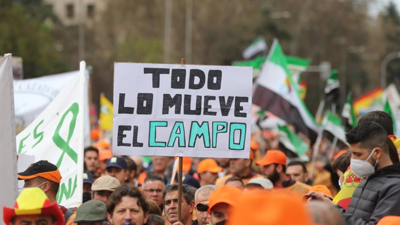 Varios manifestantes, con gorras naranjas con una pancarta que reza 'Todo lo mueve el campo', durante la la marcha por el mundo rural ‘20M’, a 20 de marzo de 2022, en Madrid | Isabel Infantes - Europa Press ep varios manifestantes con gorras naranjas con una pancarta que reza todo lo mueve el campo durante