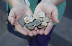 ep archivo   una persona muestra un punado de monedas de las antiguas pesetas mientras hace cola