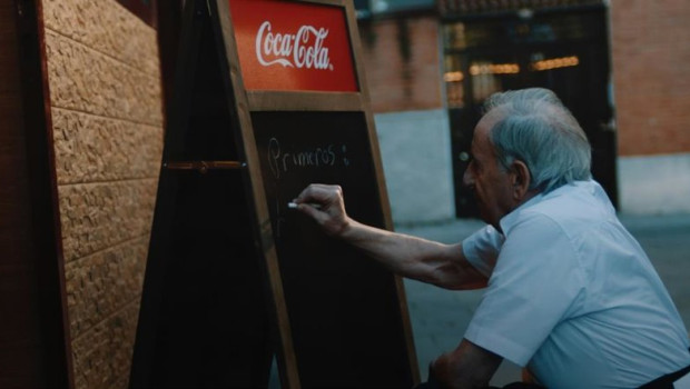 ep camarero escribiendo menu en pizarra de coca cola
