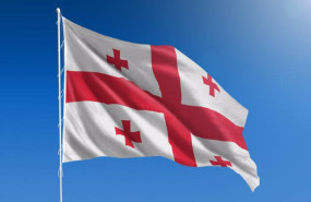 ep the national flag of georgia blowing in the wind in front of a clear blue sky