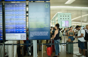 ep archivo   colas de pasajeros junto a una pantalla que avisa de los problemas causados por la