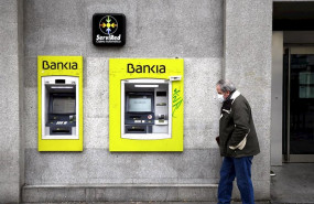 ep un hombre con mascarilla pasa por delante de un cajero de bankia