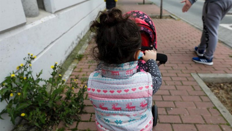 ep una nina pasea por la calle empujando un carrito con un bebe de juguete junto a su padre y su ep una nina pasea por la calle empujando un carrito con un bebe de juguete junto a su padre y su