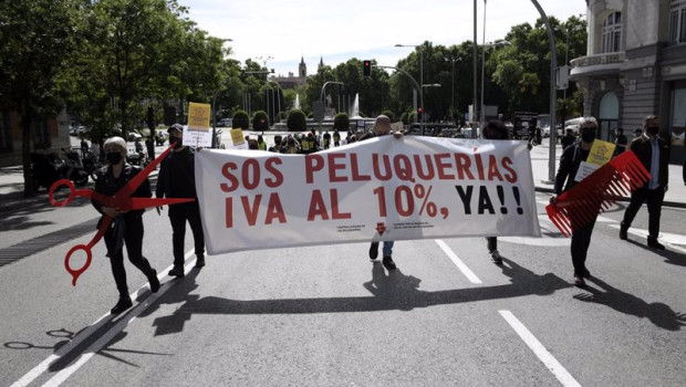 ep grupos de personas se manifiestan con una pancarta donde se puede leer sos peluquerias iva al 10