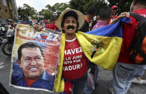 ep un hombre sostiene una fotografia de hugo chavez