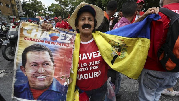 ep un hombre sostiene una fotografia de hugo chavez