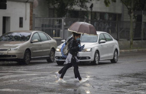 ep dos personas cruzan un charco de agua durante la alerta amarilla por lluvia en el estado de