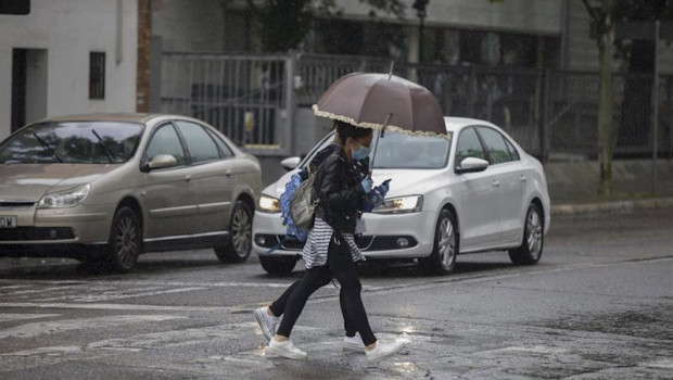 ep dos personas cruzan un charco de agua durante la alerta amarilla por lluvia en el estado de