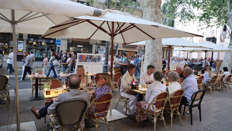 ep varias personas en una terraza durante una manifestacion contra la masificacion turistica y por ep varias personas en una terraza durante una manifestacion contra la masificacion turistica y por