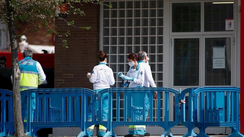 El equipo de UVI Móvil durante la desinfección de su ambulancia junto al Pabellón Carlos Sastre en el que funciona un hospital de campaña desde hace una semana en las inmediaciones del Hospital Severo Ochoa. | Óscar J.Barroso - Europa Press ep el equipo de uvi movil durante la desinfeccion de su ambulancia junto al pabellon carlos sastre