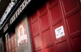ep entrada cerrada de un bar de madrid en el que un cartel dice cerrado por precaucion un dia antes