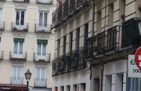 ep un hombre con paraguas pasa por debajo de un cartel que anuncia un piso en alquiler