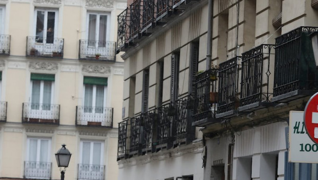 ep un hombre con paraguas pasa por debajo de un cartel que anuncia un piso en alquiler