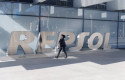 ep archivo   una mujer camina frente a las letras repsol en su sede de madrid