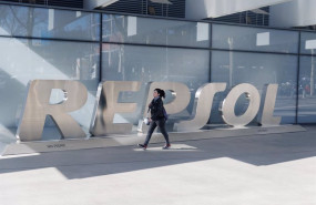 ep archivo   una mujer camina frente a las letras repsol en su sede de madrid