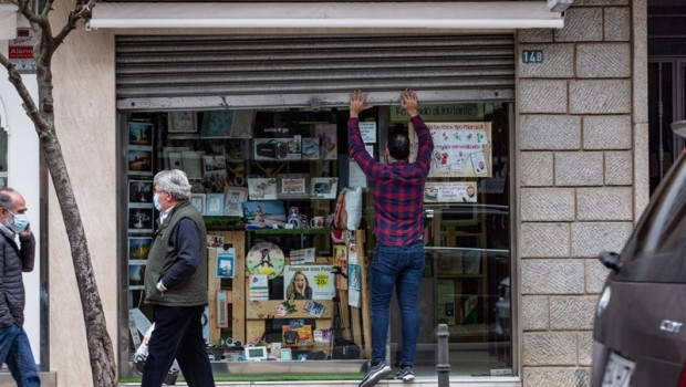 ep un hombre levanta la cortina metalica de un comercio en badajoz extremadura espana