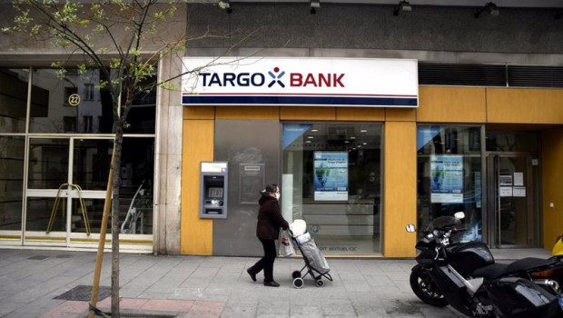 ep una mujer protegida con mascarilla pasa delante de una oficina targobank