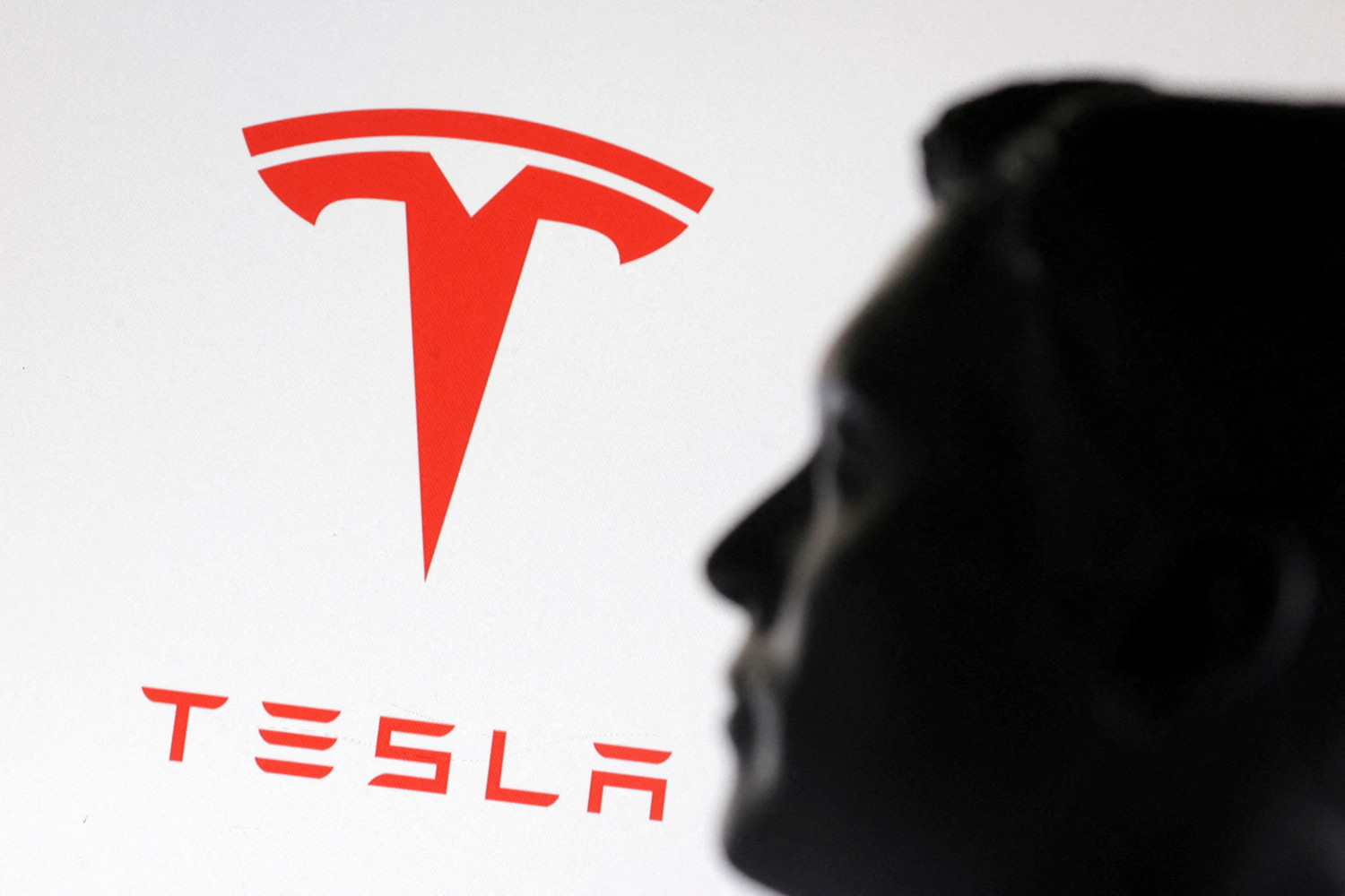 une illustration montre un modele miniature imprime en 3d d elon musk et du logo tesla une illustration montre un modele miniature imprime en 3d d elon musk et du logo tesla