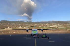 ep archivo   un avion de binter en la pista del aeropuerto de la palma con el volcan en erupcion al