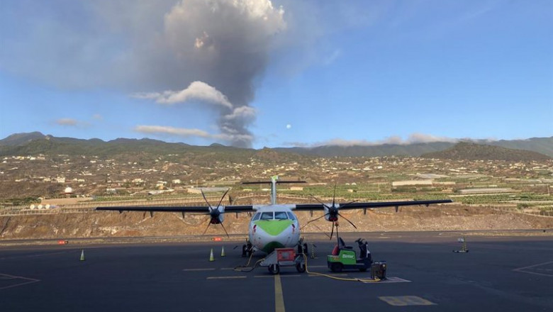 ep archivo   un avion de binter en la pista del aeropuerto de la palma con el volcan en erupcion al