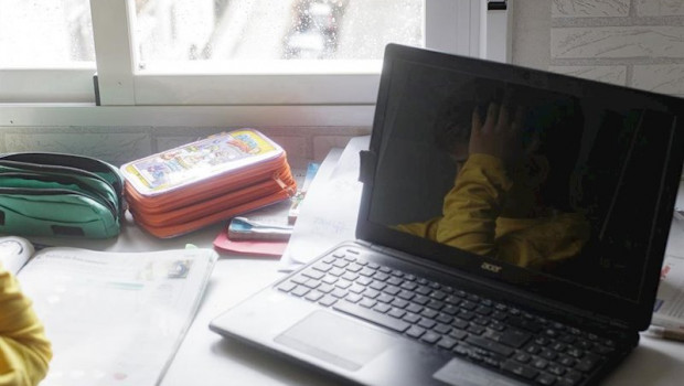 ep reflejo en un ordenador portatil de un nino estudiando y haciendo los deberes en casa a 15 de