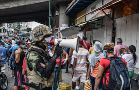 ep un agente de la fuerza boliviariana de venezuela explica a la poblacion que debe regresar a sus