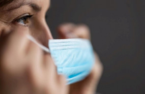 ep una mujer se coloca una mascarilla