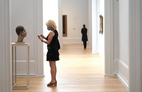 ep una visitante protegida con mascarilla le hace una foto con su telefono movil a una escultura el