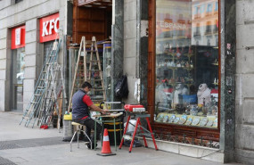 ep archivo   un hombre protegido con mascarilla trabaja en la puerta de su ferreteria