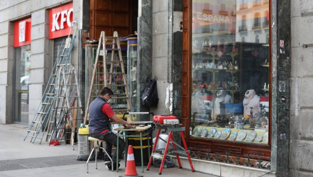 ep archivo   un hombre protegido con mascarilla trabaja en la puerta de su ferreteria