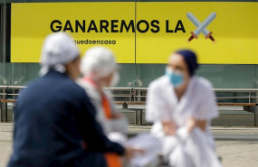 ep sanitarios junto a un cartel en el que se lee ganaremos la batalla en el hospital de campana de