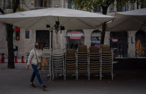 ep una mujer pasa junto a la terraza recogida de un bar