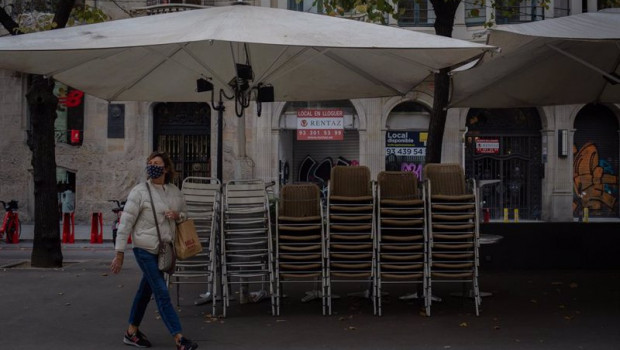 ep una mujer pasa junto a la terraza recogida de un bar