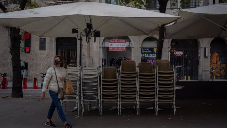 ep una mujer pasa junto a la terraza recogida de un bar