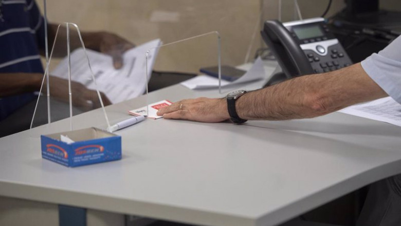 ep archivo   un empleado atiende a una persona en su puesto de trabajo de una oficina de hacienda